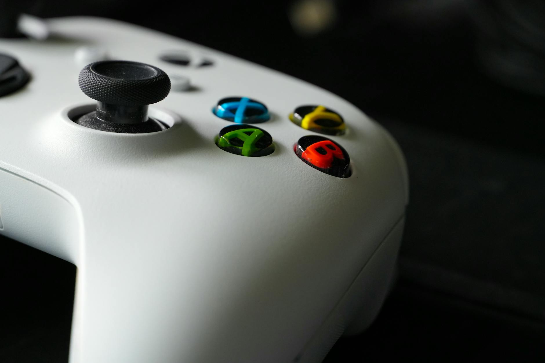 Black gaming controller on dark surface representing console gaming hardware