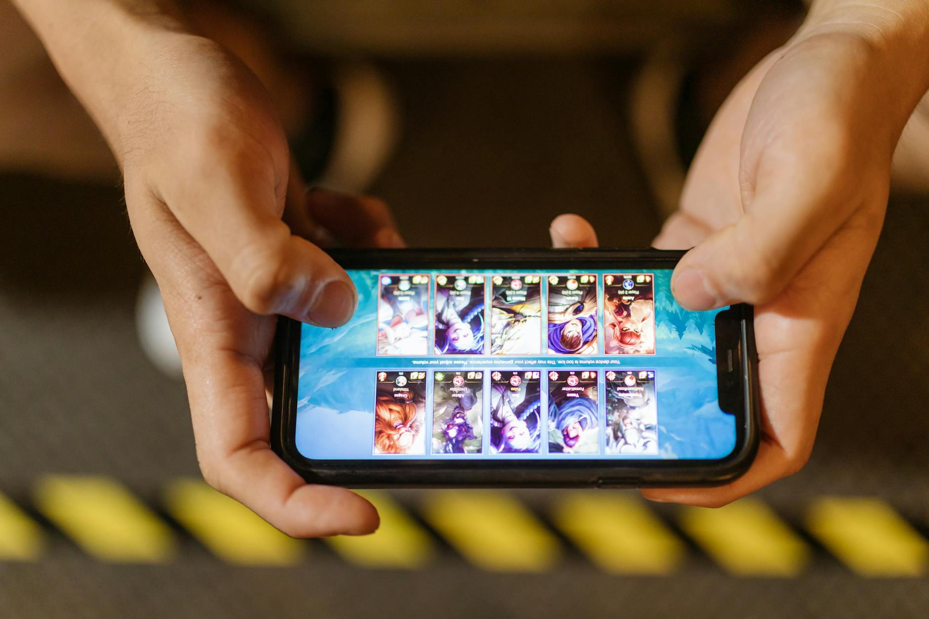 Person playing mobile game on smartphone with focused concentration