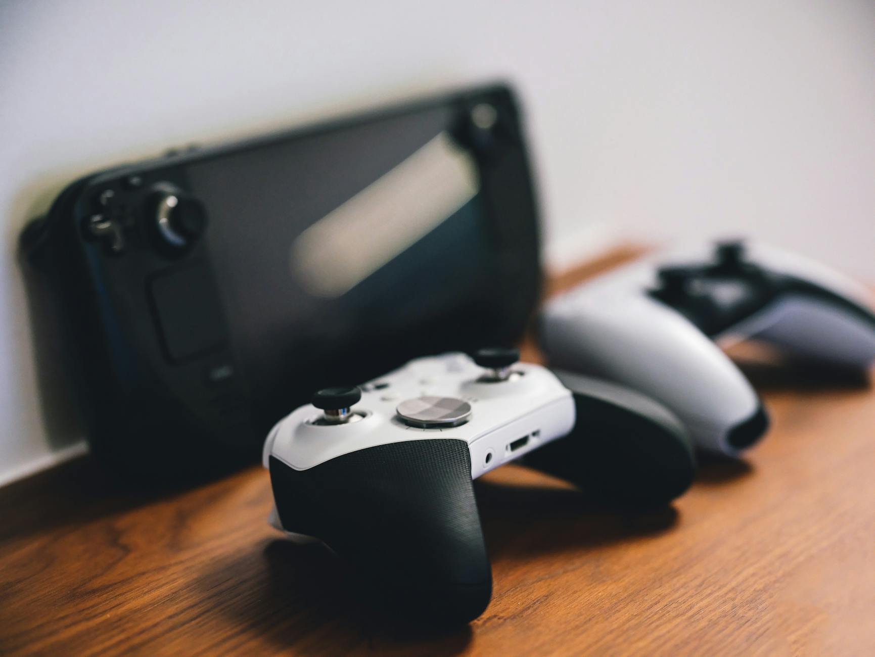 Modern gaming handheld device on wooden surface showing competitive portable gaming market