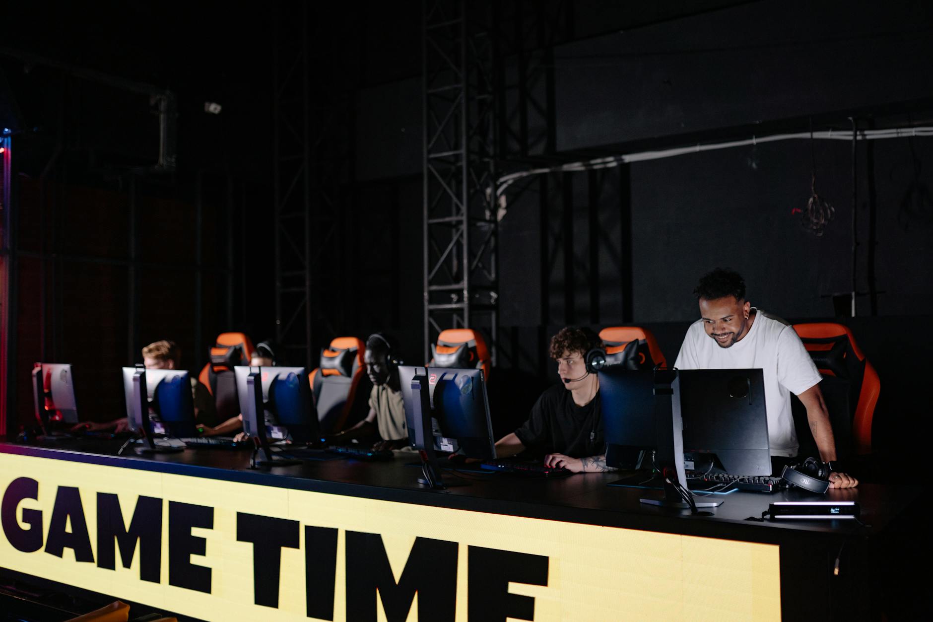 Professional esports tournament setup with multiple gaming stations and large screens