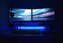 Gaming computer setup with multiple monitors displaying Steam interface and Workshop content