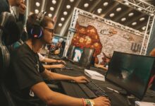 Professional esports tournament setup with multiple gaming stations and large screens displaying competition