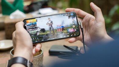 Person playing mobile game on smartphone with focused concentration