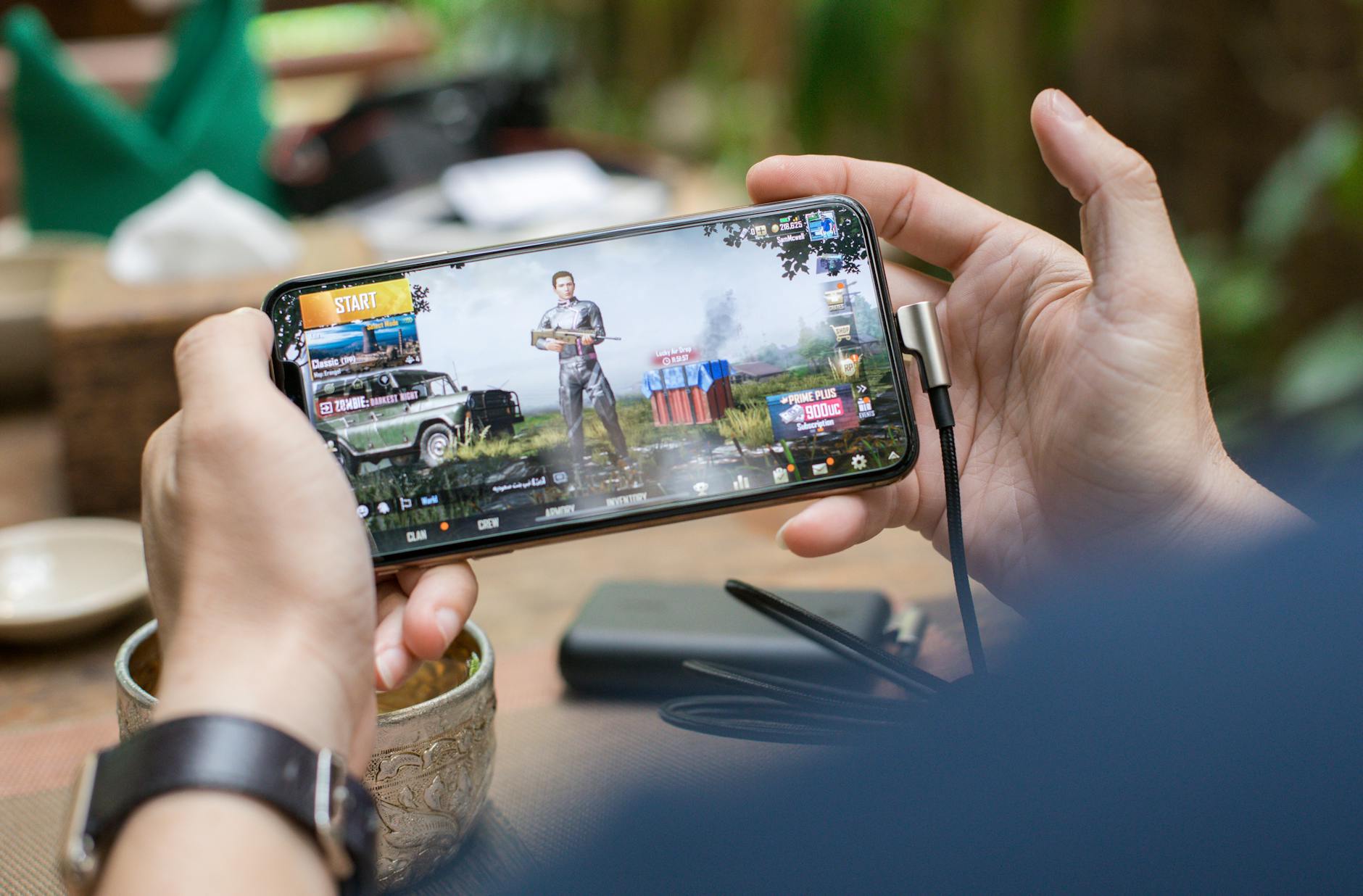 Person playing mobile game on smartphone with focused concentration