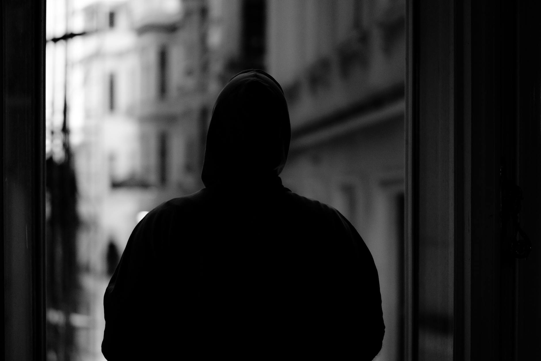 Mysterious hooded figure in shadows representing stealth gameplay mechanics