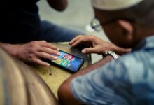 Person holding smartphone displaying mobile gaming interface