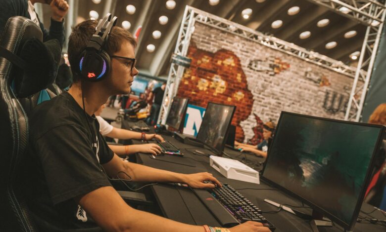Large esports tournament arena with screens and crowd of spectators watching competitive gaming event