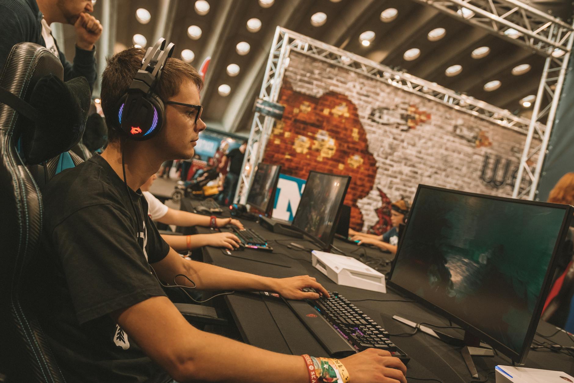 Large esports tournament arena with screens and crowd of spectators watching competitive gaming event