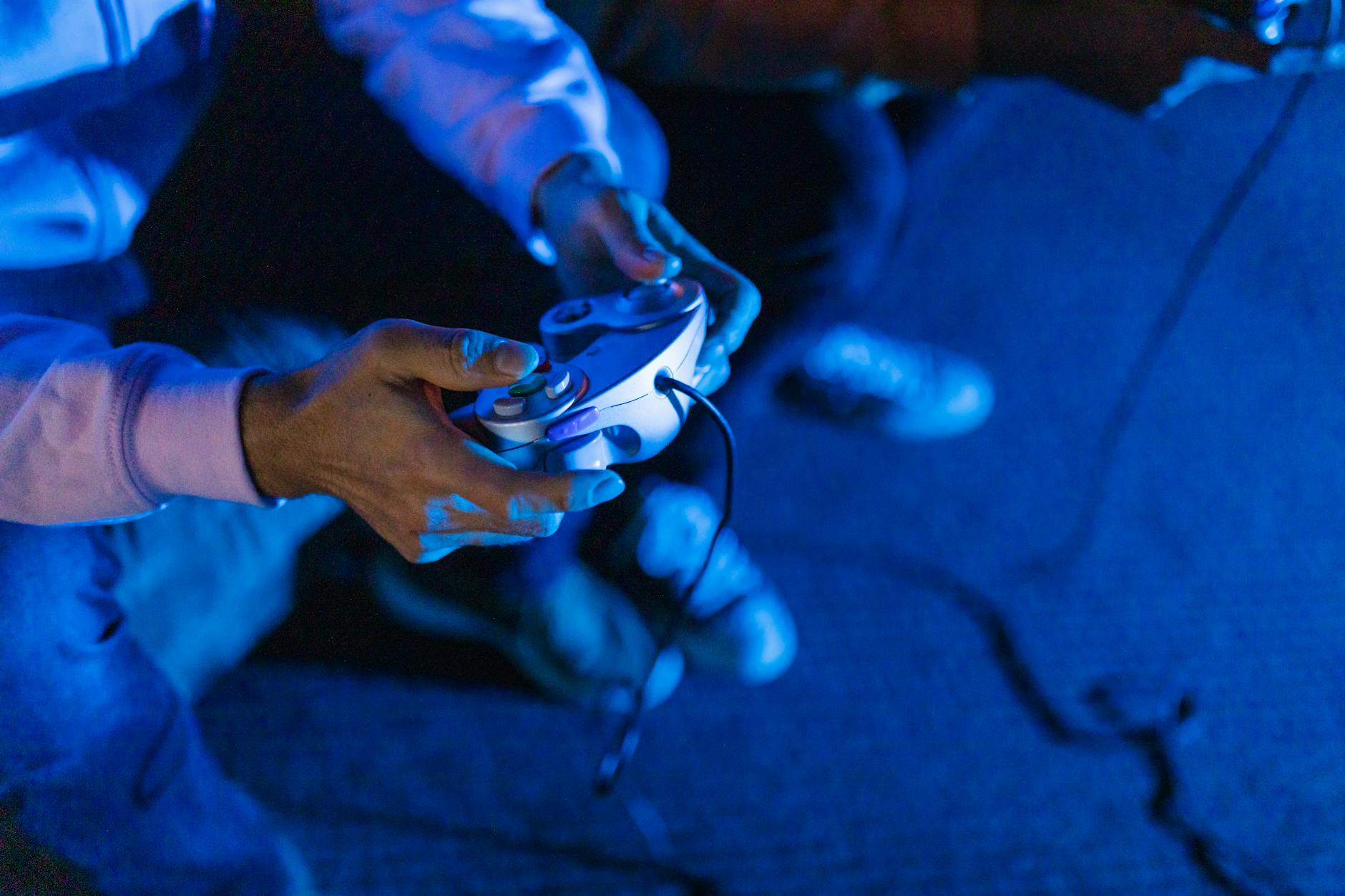 Hands holding video game controller during gaming session