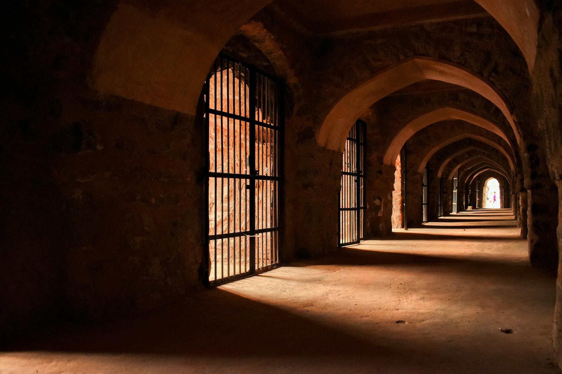 Atmospheric dark stone dungeon corridor with torch lighting and medieval architecture