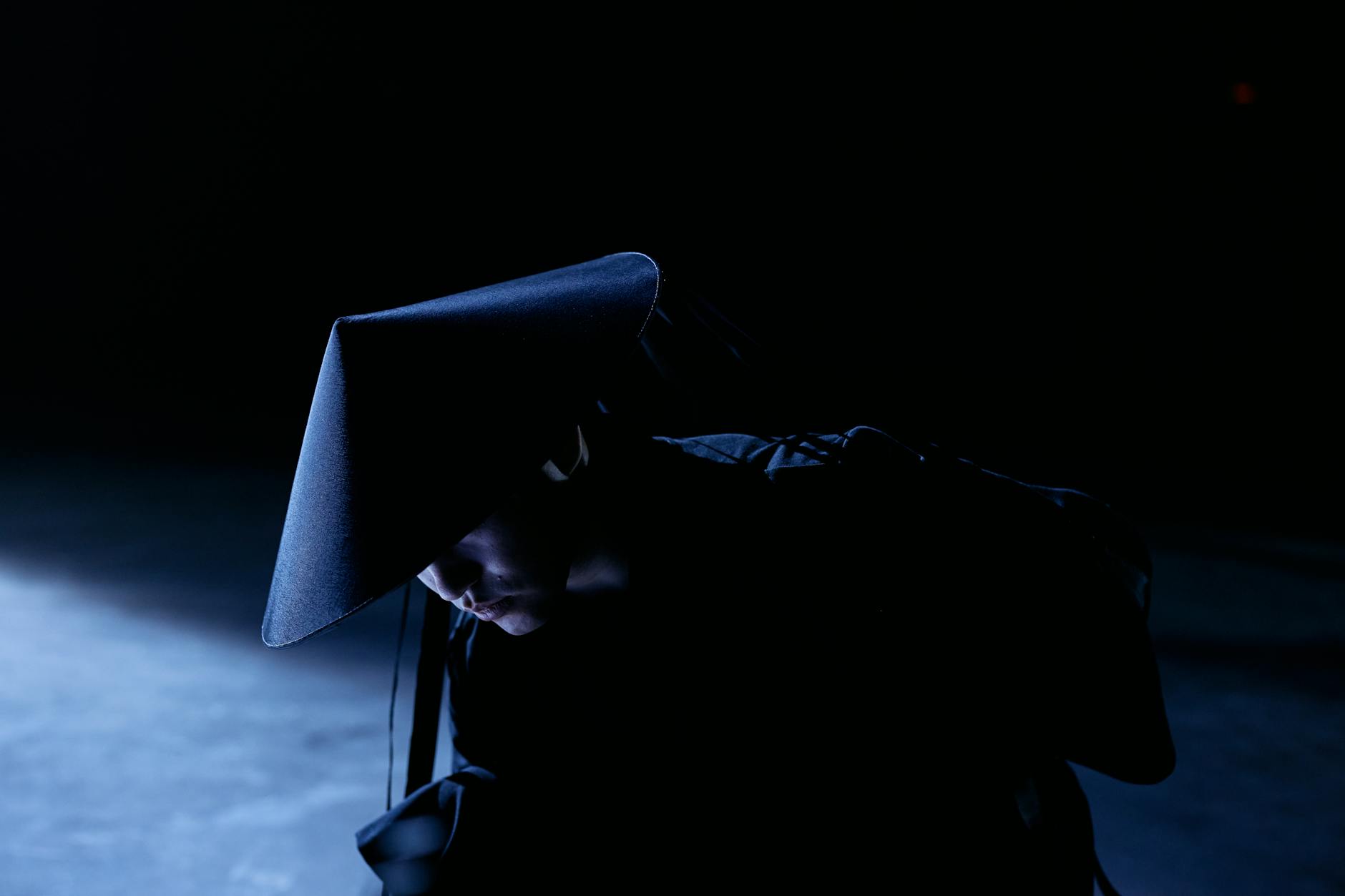 Dark silhouette figure crouched in stealth position against moody background