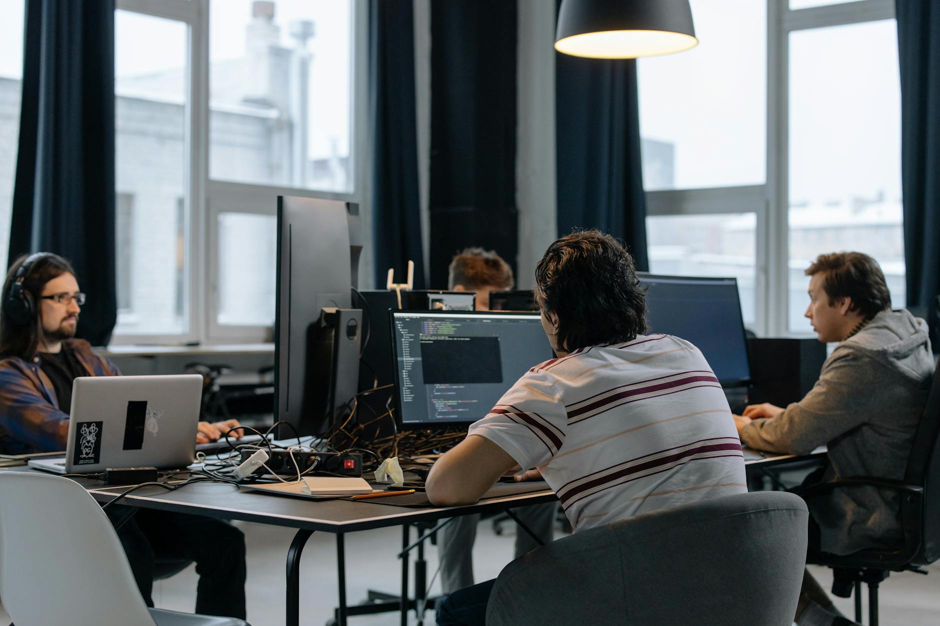 Business professionals shaking hands over technology documents in modern office