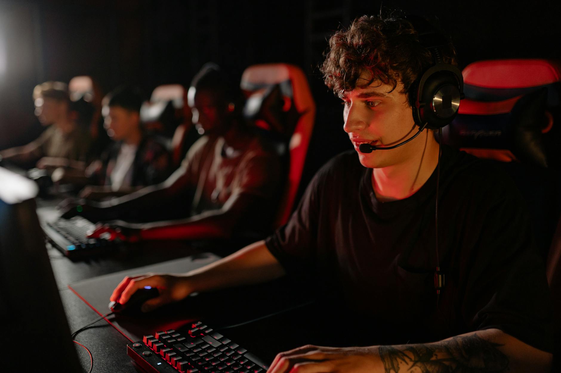 Competitive gaming environment showing players focused on screens during a tournament match