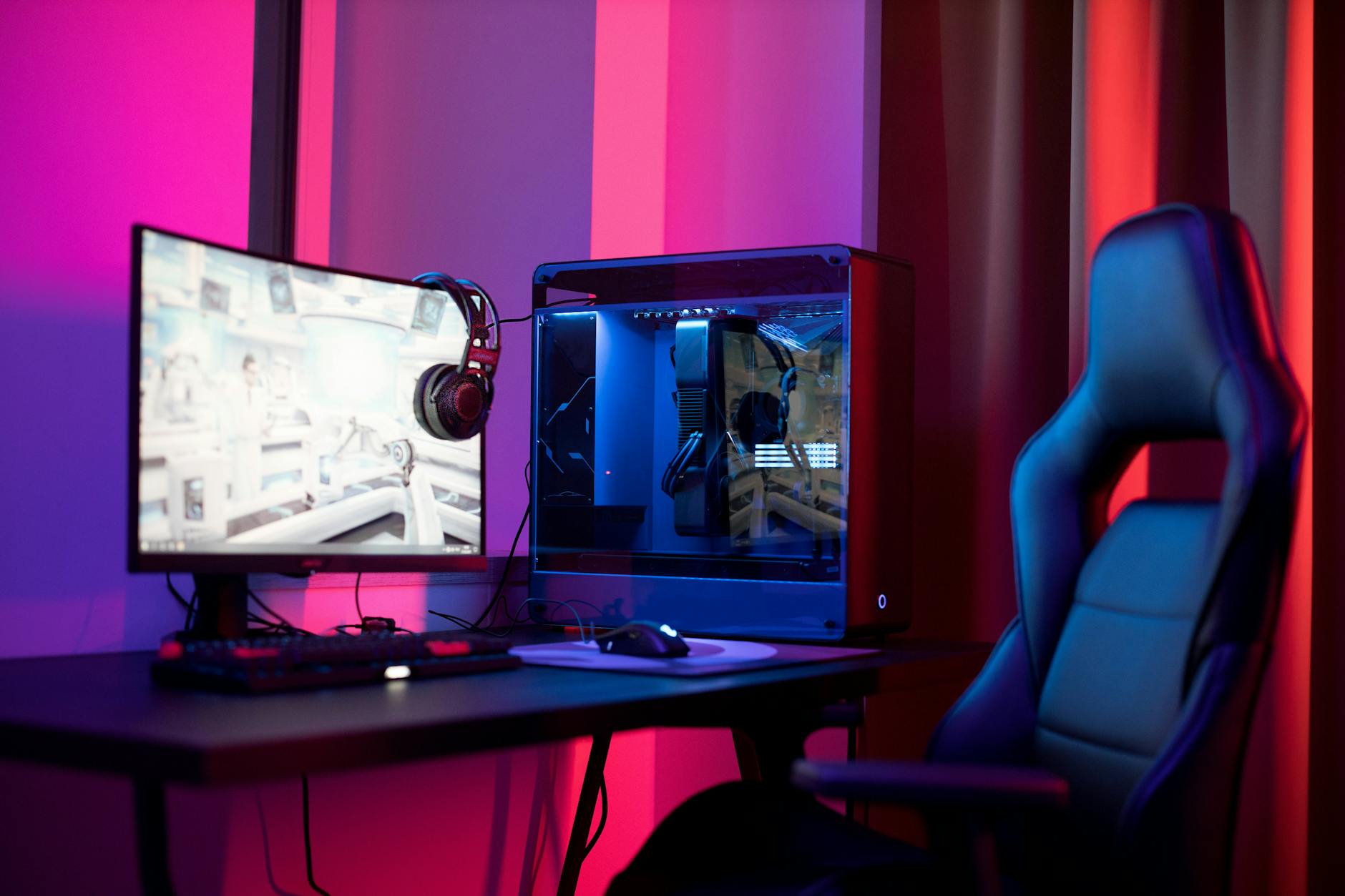 Gaming PC desktop setup with RGB lighting and monitor displaying a game