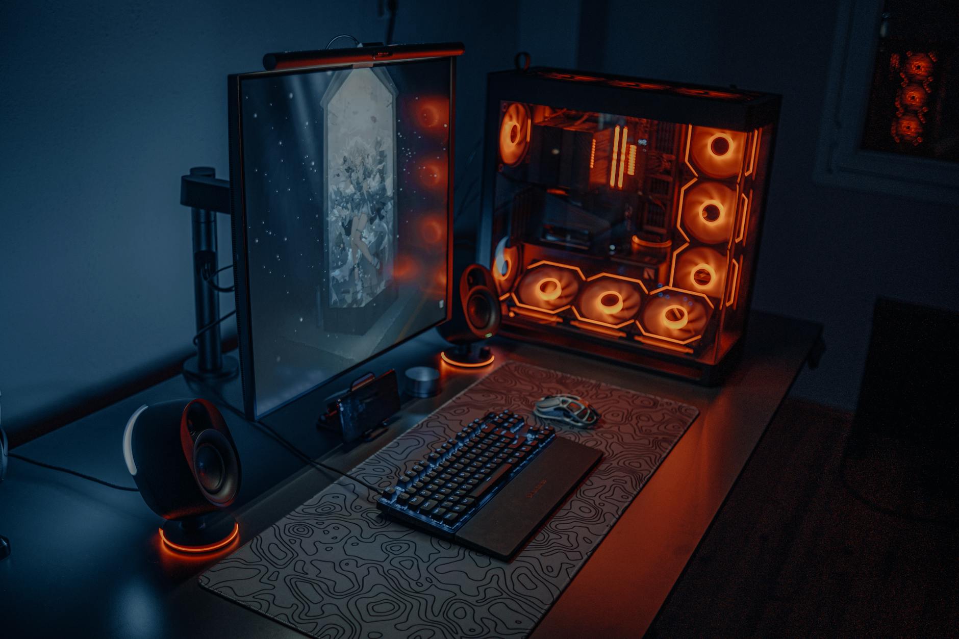 Gaming computer setup with mechanical keyboard and monitor displaying colorful game graphics