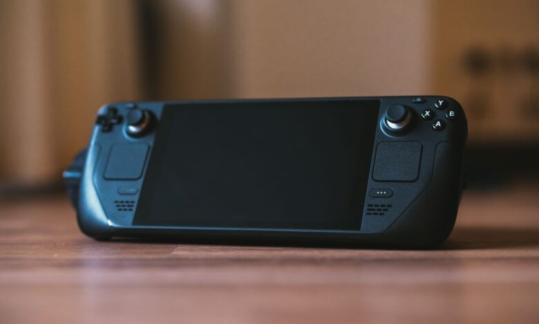 Handheld gaming PC held in two hands showing game running on screen