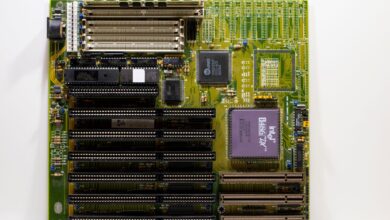 High-end AMD X870E gaming motherboard with VRM heatsinks and RGB lighting visible on a dark surface