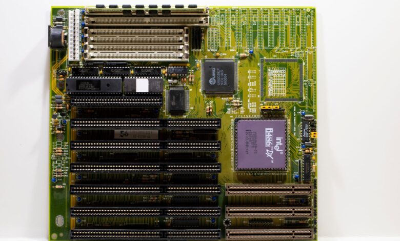 High-end AMD X870E gaming motherboard with VRM heatsinks and RGB lighting visible on a dark surface