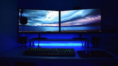 Two OLED gaming monitors displayed side by side on a PC gaming desk setup