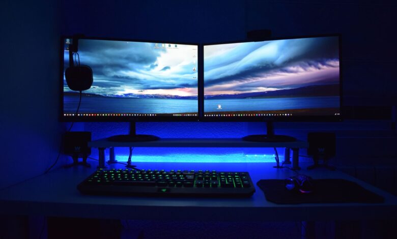 Two OLED gaming monitors displayed side by side on a PC gaming desk setup