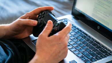 High-end gaming laptop open on a desk displaying a graphics-intensive game