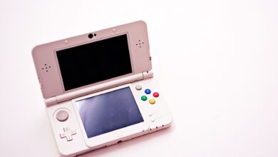 A handheld gaming PC held in two hands showing a game on screen